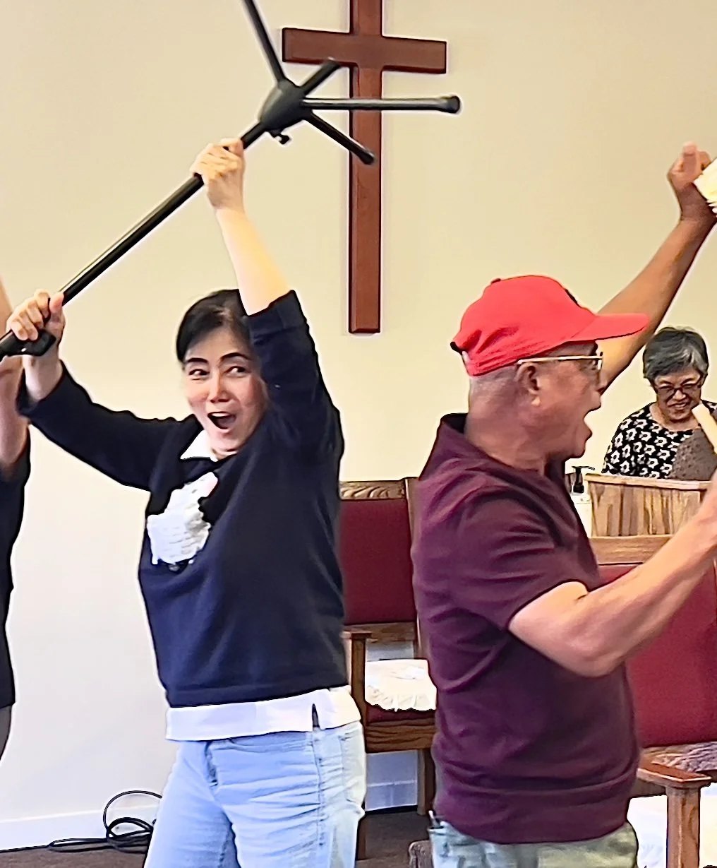 Worshippers with hands raised in front of the sanctuary cross