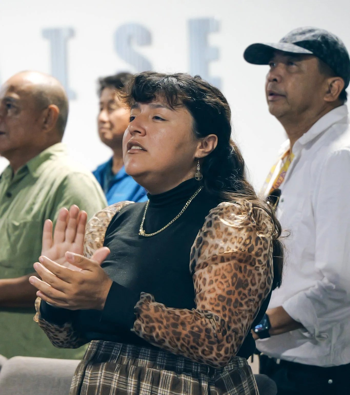 A young woman praising during worship at All Nations Church